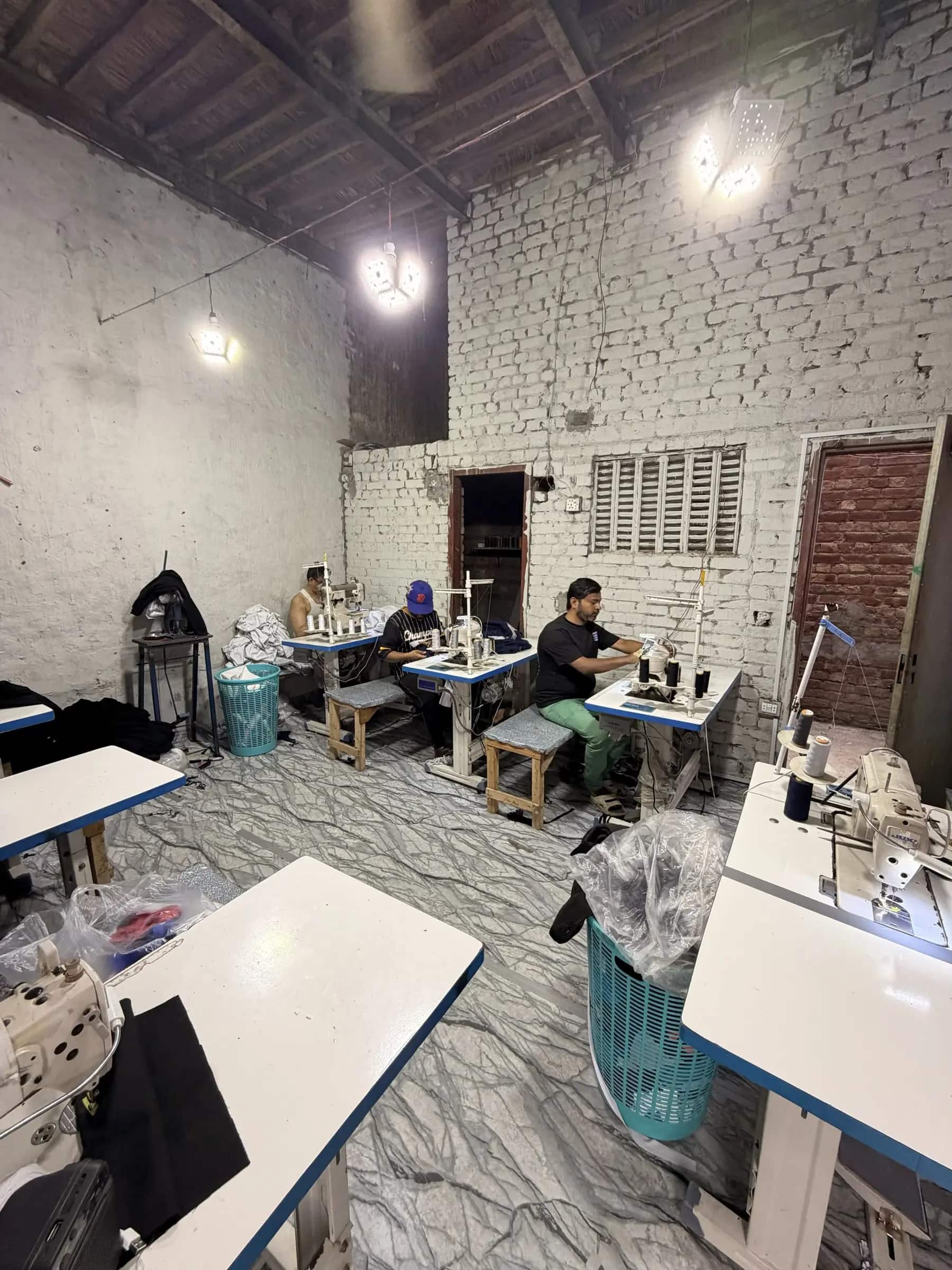 Sewing operators at industrial machines on the production floor — Mughal Apparel, Daska, Sialkot, Pakistan